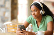 Pensive woman listening audio with phone and headphone