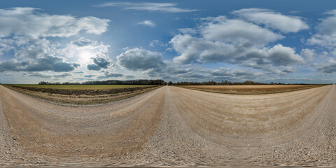 Wall Mural - hdri 360 panorama on gravel road among fields in spring nasty day with awesome clouds in equirectangular full seamless spherical projection, for VR AR virtual reality content