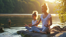 A Woman And Her Daughter Practice Yoga On The River Bank. The Connection Between Mind And Body