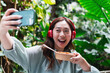 © Westend61 - Happy woman taking selfie with food container
