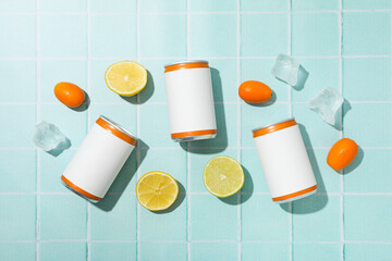 Sticker - Tin cans, ice cubes and citrus fruits on blue background, top view