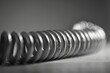 Close-up of a coiled Pilates spring with a hint of resistance, ready for a dynamic exercise.