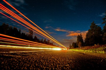 Poster - Stunning nighttime image of an empty road illuminated by light trails