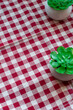 checkered red and white tablecloth with two green decors. Free place for logo and text