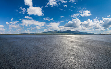 Wall Mural - Asphalt road square and mountains with sky clouds background