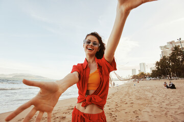 Wall Mural - Smiling Woman Embracing Freedom, Enjoying Colorful Sunset over Ocean