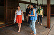 © Studio Marmellata - group of Japanese friends laugh and interact in a lively manner on the steps of a traditional wooden building