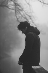 Wall Mural - A man is standing on a bridge, looking out over a body of water