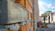 Brick wall being constructed with fresh cement, highlighting the craft of masonry and the process of building.