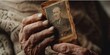 A man is holding a picture of an older man. The photo is old and worn, and the man's hands are wrinkled. Concept of nostalgia and the passage of time
