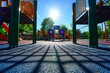 © Ifti Digital - Children playing on a playground with a slide and a play structure, A playground with shadow patterns under the bright sun, AI Generated