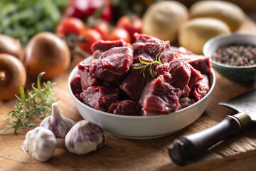 Wall Mural - Pieces of chopped beef in a bowl with vegetables, ready for goulash