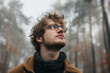 © ADDICTIVE STOCK - A thoughtful young man gazes upwards amidst a misty forest backdrop, a contemplative image captured by Generative AI