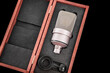 Podcast studio microphone in a case on a black background.