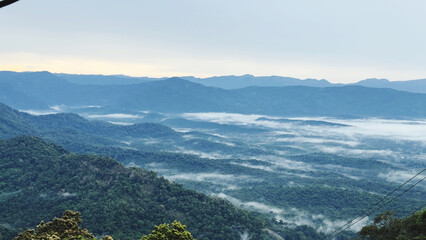 Wall Mural - mountains are shroud with mist and clouds as seen through a window