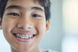 smiling teenage asian boy with braces, close up portrait of asian teen, orthodontic treatment, blurred background