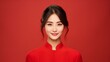 Beautiful Asian woman with clean fresh skin wearing cheongsam dress holding red envelopes or Ang Pao on red background. Happy Chinese new year. Chinese text means great luck great profit.