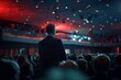 Rear view of a businessman at a conference event looking at a presentation among an audience under colorful lighting.