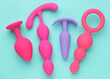 anal plugs and dildo sex toys over turquoise blue background