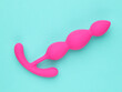 Pink sex toy isolated over turquoise blue background