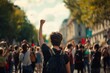 Back view of a young protester with raised fist amidst a crowd at a street demonstration, conveying activism and solidarity.