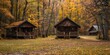 A small cabin is surrounded by trees and leaves. The cabin is in a wooded area and has a rustic feel