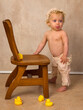 Blonde baby first steps holding chair