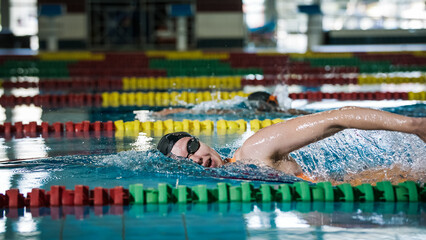 Elite female athlete, professional swimmer during a front crawl swimming workout. Concept of hard training for a competition.