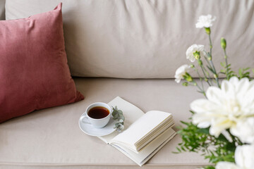 Wall Mural - Selective focus on cup with tea and diary on white soft comfortable armchair