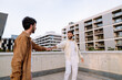 © BullRun - Romantic gay men holding hands on building terrace