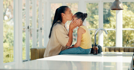 Wall Mural - Kiss, mother and child ready for school on a kitchen table with a backpack and smile. Morning, girl kid and woman together at home to prepare for education or learning with love and care of a mom