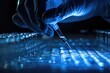 © Larisa - A researcher uses a pipette over test tubes in a lab with a blue light.
