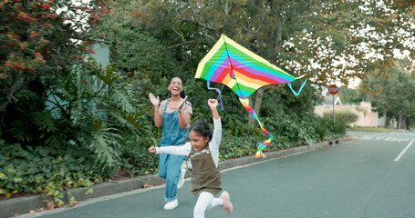 Wall Mural - Family, flying a kite and girl with her mother outdoor together on the street for carefree or playful bonding. Kids, love and a woman running with her excited daughter while playing a game in summer