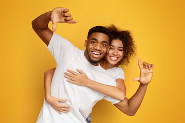 Wall Mural - Couple having fun taking picture with imaginary camera