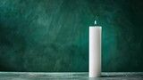 Fototapeta Kosmos - A minimalist white candle standing tall against a serene forest green backdrop