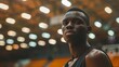 portrait of anonymous black male basketball player inside a basketball stadium in blurred background