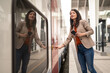 Business woman entering a train on train station, using mobile phone, looking away