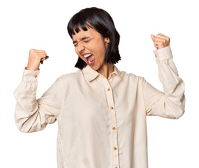 Poster - Young Hispanic woman with short black hair in studio raising fist after a victory, winner concept.