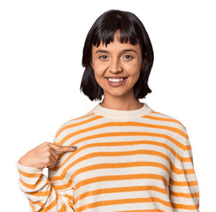 Poster - Young Hispanic woman with short black hair in studio person pointing by hand to a shirt copy space, proud and confident