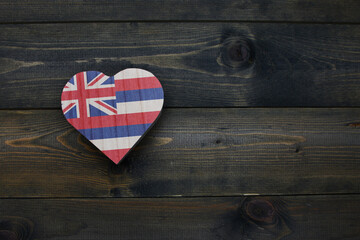 Wall Mural - wooden heart with national flag of hawaii state on the wooden background.