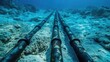 Undersea internet cables. Submarine communications cable. Underwater view of parallel pipelines stretching into the distance along a sandy ocean floor, technological advances in marine engineering