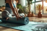Fototapeta  - Yoga at home active lifestyle woman rolling exercise mat in living room for morning meditation yoga banner background