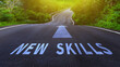 © rawintanpin - Self development concept and changing skill demand idea, New skills and arrow written on asphalt road, New skills concept.
