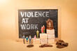 Violence At Work. Chalkboard and miniature human figures on a light background