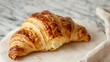 Golden delicious croissant with flaky pastry on a marble countertop in a French bakery setting for breakfast