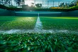 Before a match, a tennis court with recently cut grass is shown up close.