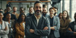 © MD Media - Diverse group of business people team standing in an office, smiling and looking at the camera with arms crossed. A man posing as the leader is in the center posing for a portrait