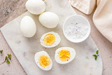 Fototapeta Mapy - Boiled eggs peeled and cut in half with salt and pepper