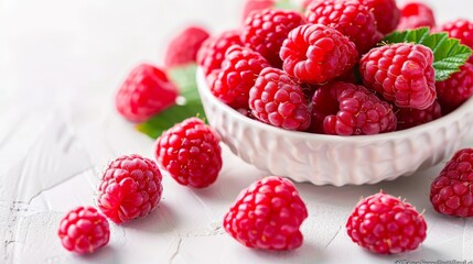 Wall Mural - Raspberries in a white bowl on a table showing freshness and deliciousness