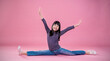 Portrait of little asian child girl dance stretch street style with jeans isolated on pink background. Happy young girl practise her dance. Education childhood pre teen lifestyle concept